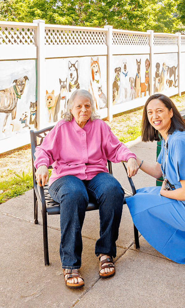 a woman sitting in a chair next to a woman