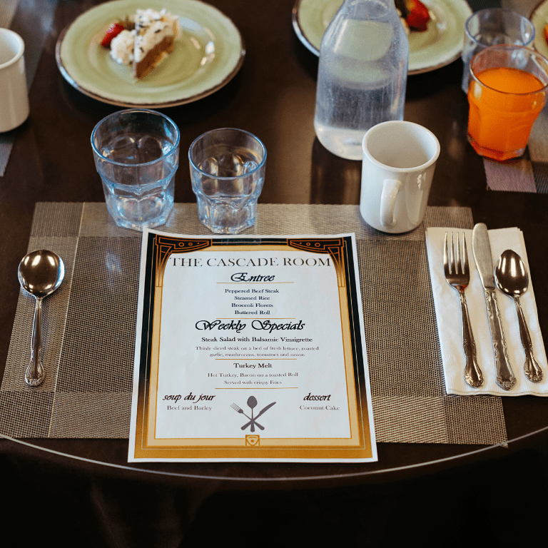 a table with plates and glasses and a menu