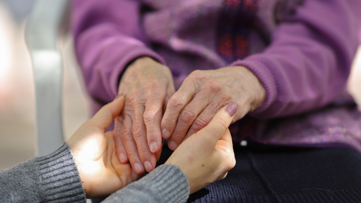 two senior ladies supporting each other by holding hands