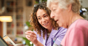 old lady reading with caregiver