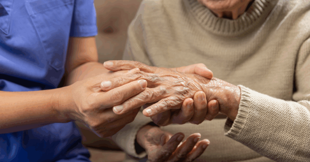 a caregiver touching an old ladie's fingers