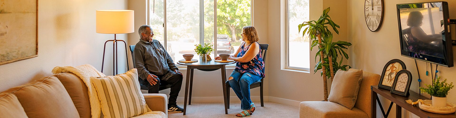a man and woman sitting at a table in a living room